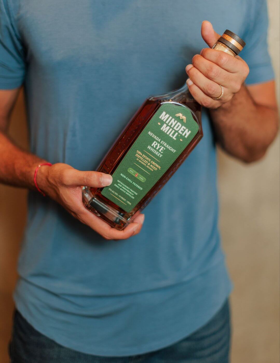 Hand holding bottle of Minden Mill Nevada Straight Rye Whiskey