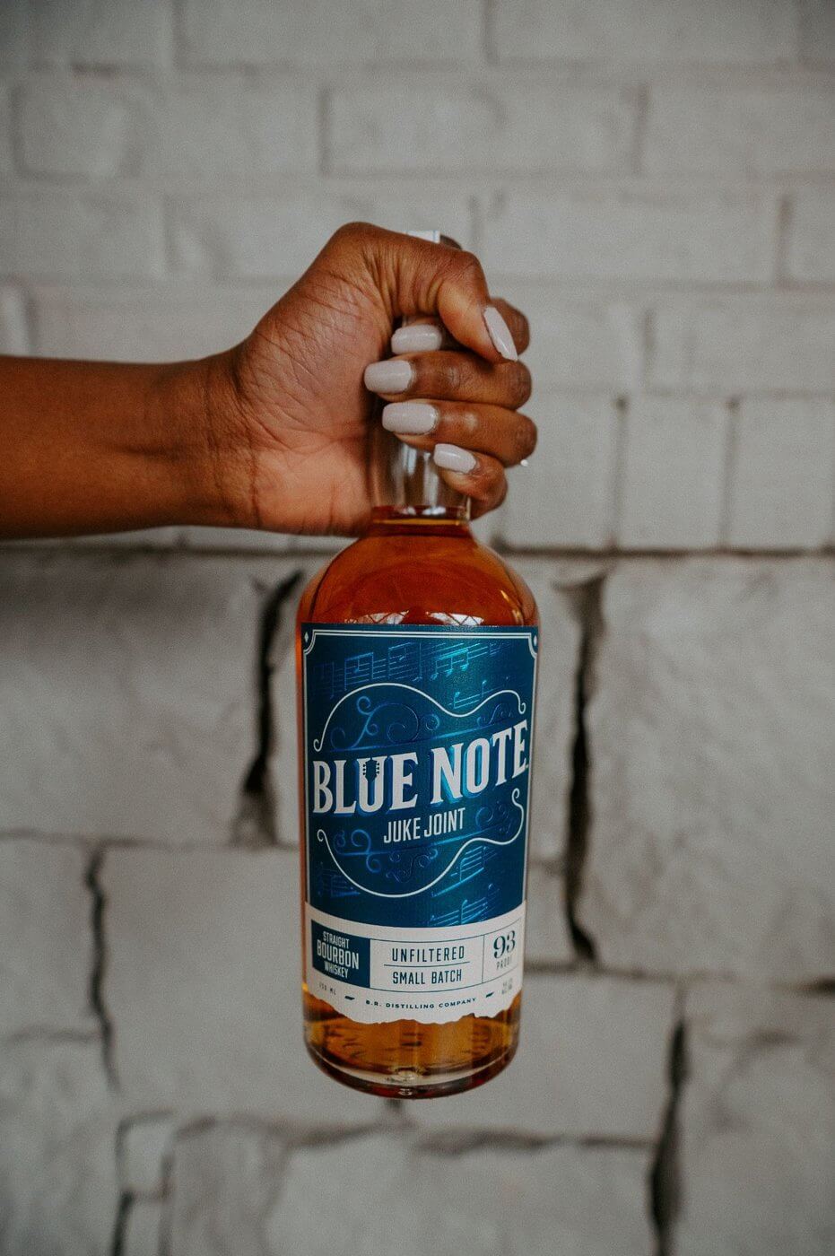 Hand holding bottle of Blue Note Juke Joint Bourbon