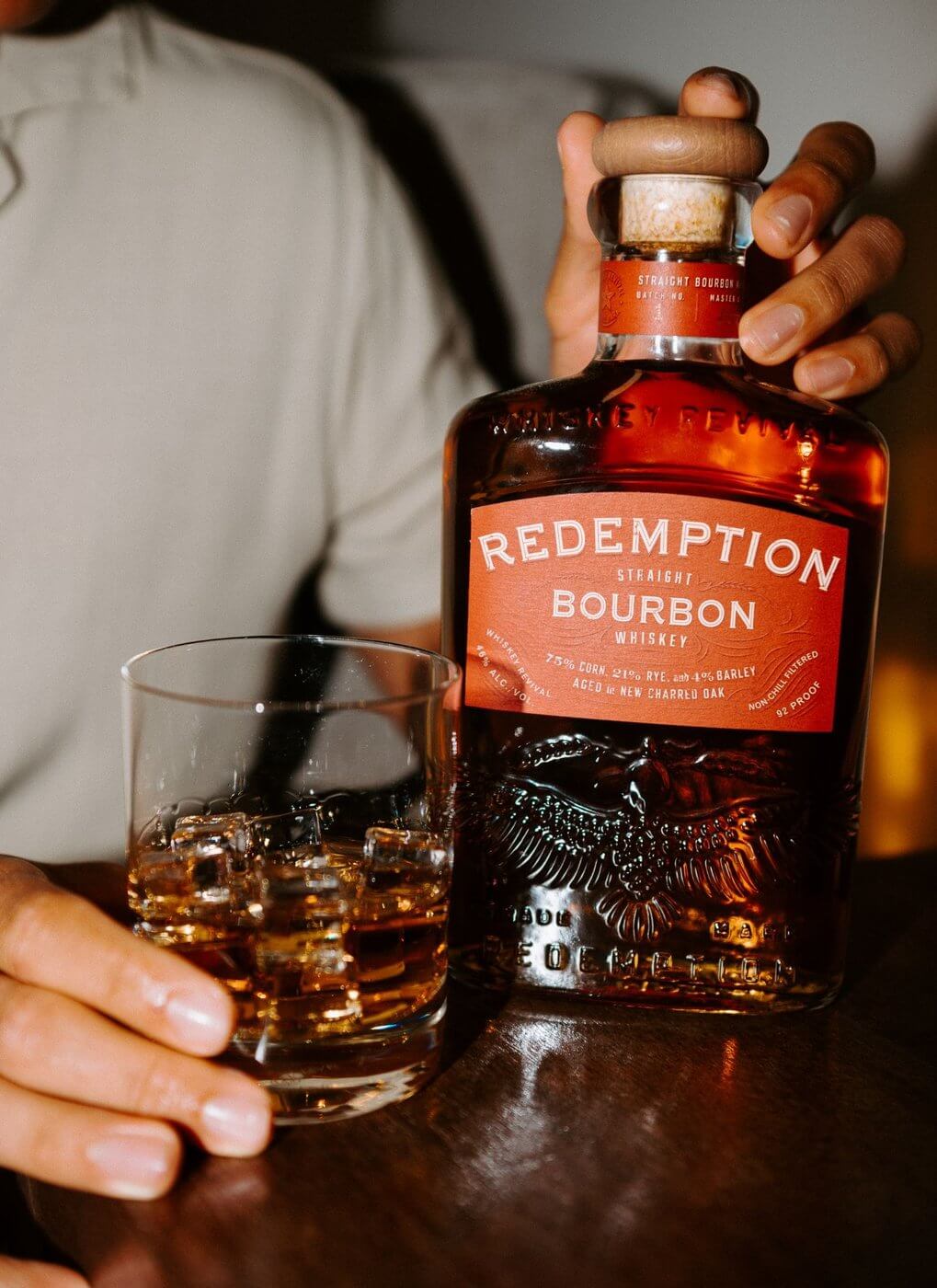 Hand holding bottle of Redemption Bourbon Whiskey