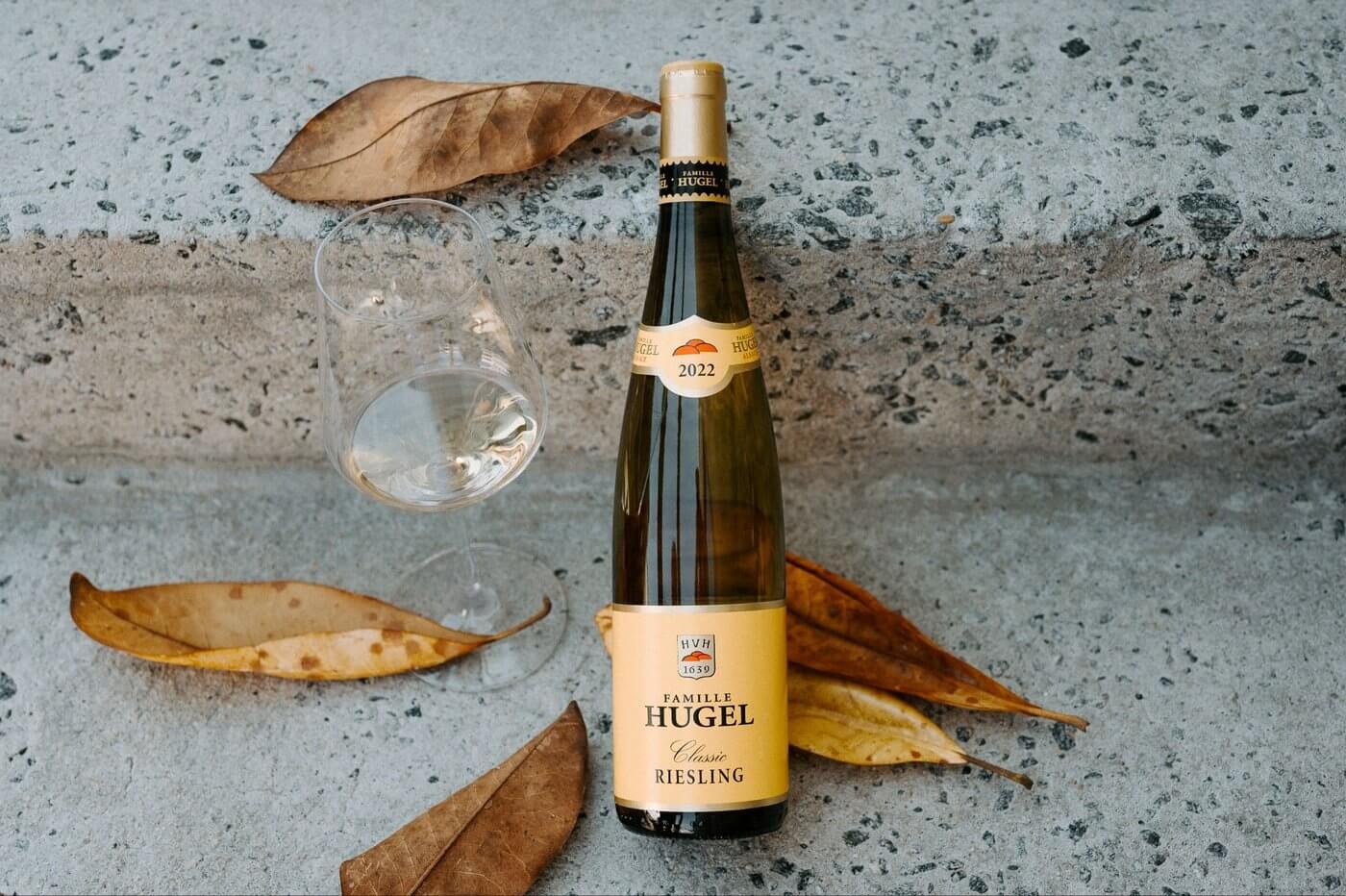 Hugel Riesling wine bottle with wine glass