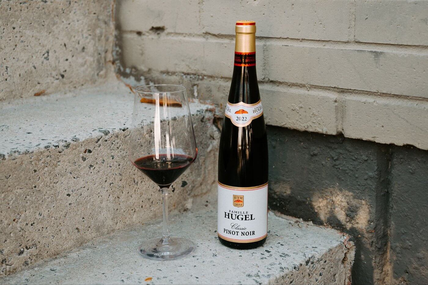 Hugel Classic Pinot Noir wine bottle with wine glass